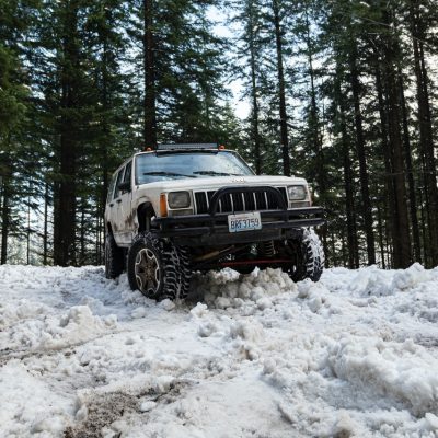 black-suv-on-snow-covered-ground-near-green-trees-3584036